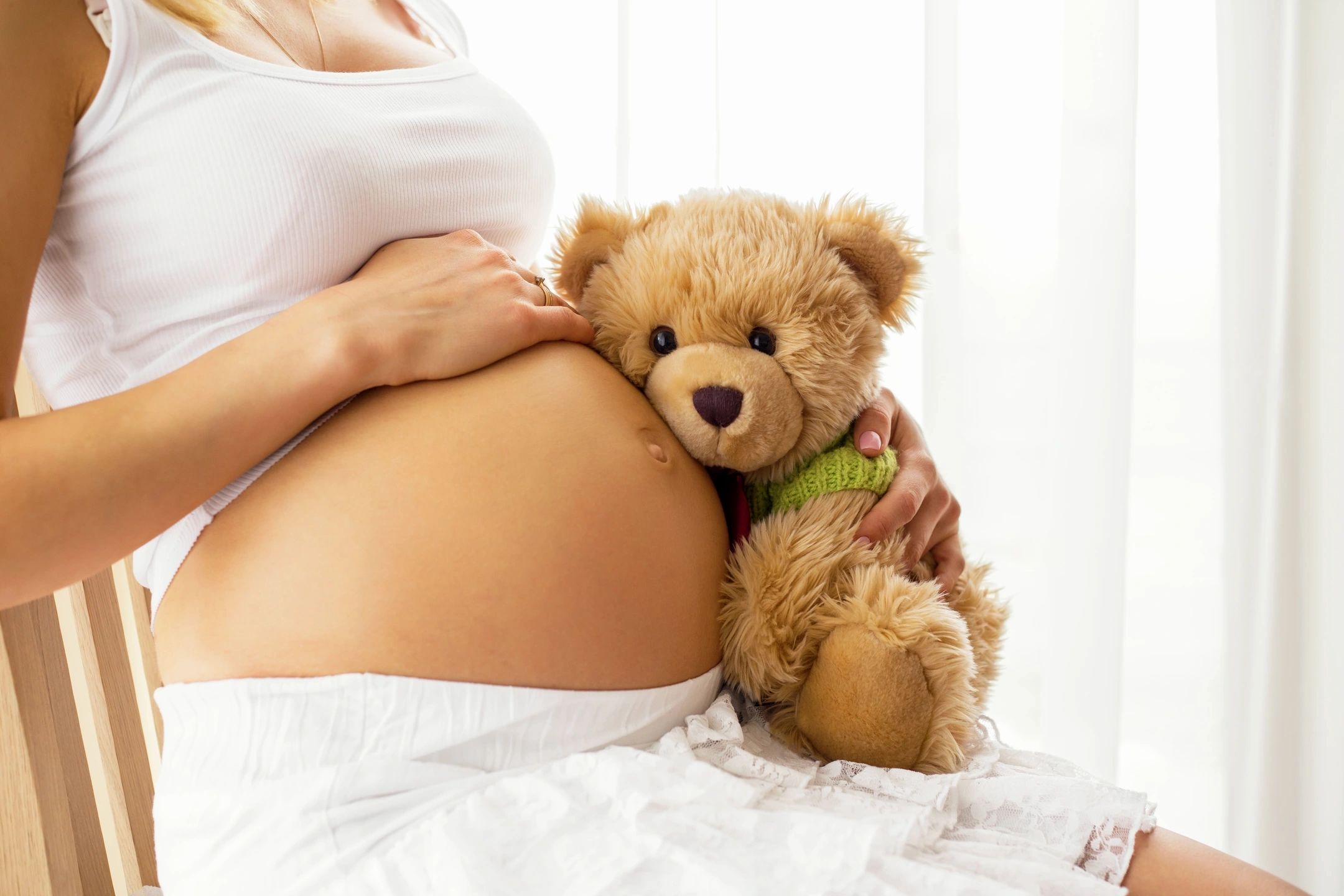 DR. John R. A woman holding a teddy bear up to her stomach