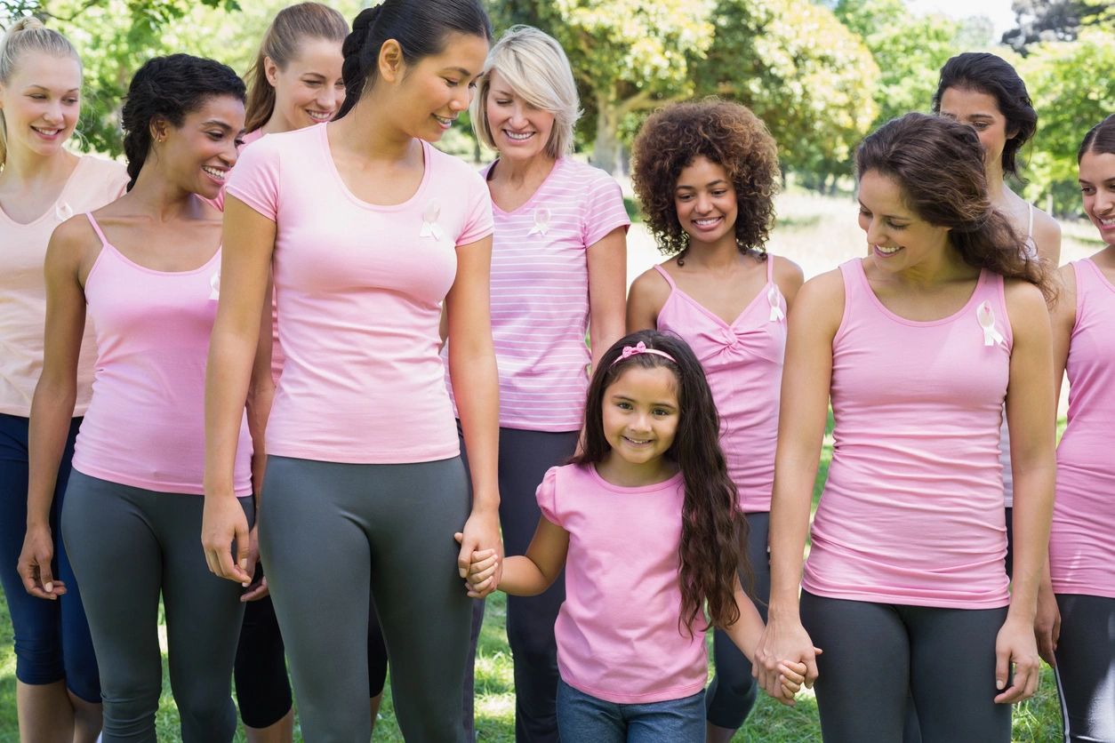 A group of woman in pink walking with a young girl also wearing pink